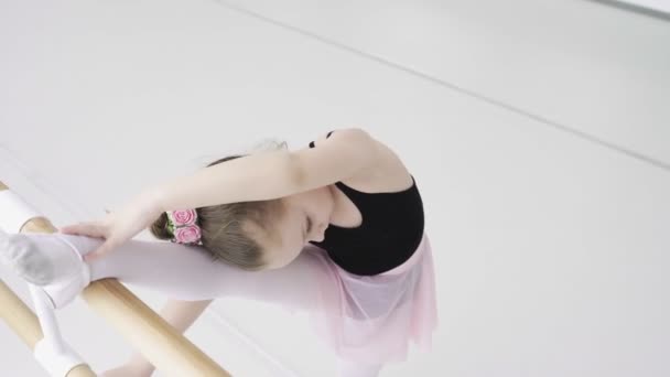Κάτοψη των μικρών κοριτσιών που χρησιμοποιούν μπάρα μπαλέτου όταν κάνουν ασκήσεις τεντώματος ποδιών στο στούντιο χορού — Αρχείο Βίντεο