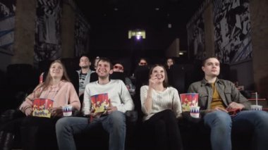 Gençler sinemada komedi filmlerine gülerler. Gençler komik komedi izlerken sinemaya gülüyorlar..