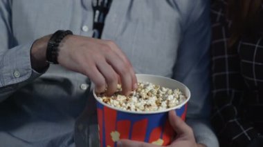 Sevgi dolu çift sinemada patlamış mısır yiyip film izliyorlar..