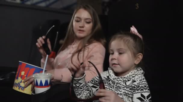 Madre con su hija están usando gafas 3d en la silla de cine . — Vídeo de stock