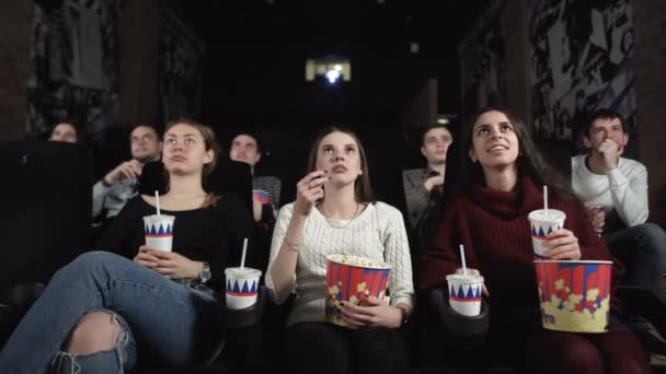 Trzy ładne przyjaciółki oglądają straszny film.Bliska kobieta reaguje z szokiem. — Wideo stockowe