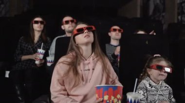 Anne ve kızı 3 boyutlu bir film izliyorlar.