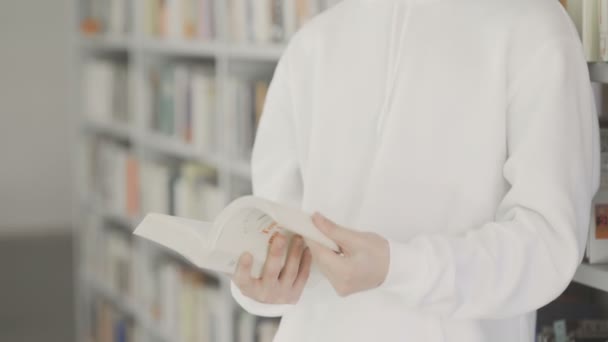 Casual elegant student har en studie i biblioteket — Stockvideo