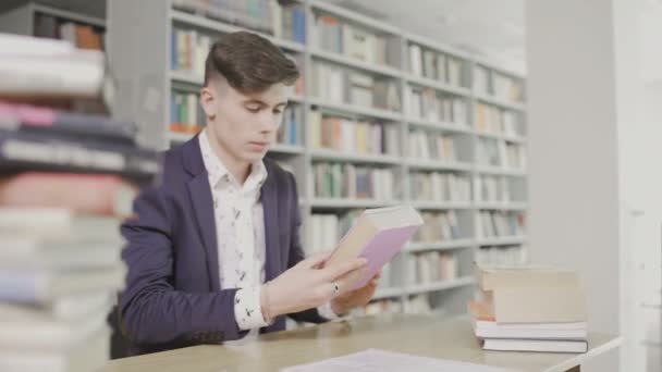 Joven estudiante en traje lee un gran libro de texto en inglés — Vídeos de Stock