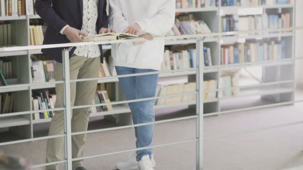 Kleiner Umzug von Studenten mit Büchern, die sich auf die Prüfung in der Bibliothek vorbereiten — Stockvideo