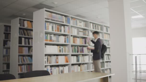 Een student kwam naar de bibliotheek en begon te lezen. — Stockvideo