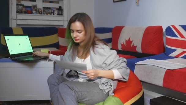 Jonge vrouw thuis Zittend op een vloer Werkt op een laptop computer met Green Mock-up Screen. Meisje met behulp van computer, Surfen via internet, Content bekijken, chatten in sociale netwerken — Stockvideo