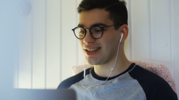 Close up de Hombre acostado en una cama y hablando en una cámara web y sonriendo — Vídeos de Stock