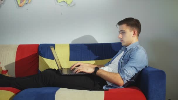 Fiatal üzletember dolgozik laptop számítógép és telefonon beszél otthon. — Stock videók