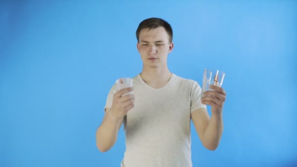 Activista joven activista con vasos de plástico y vidrio sobre fondo azul — Vídeos de Stock