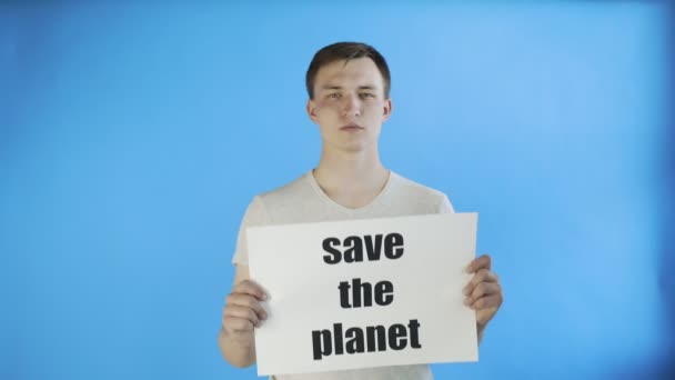 Молодий активіст із плакатом " Зберегти планету " на синьому фоні — стокове відео