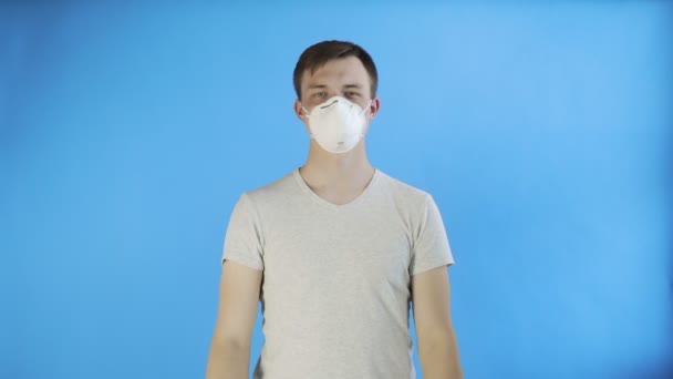 Fiatal férfi aktivista maszk az arcon, és a SEGÍTSÉG poszter kék háttér — Stock videók