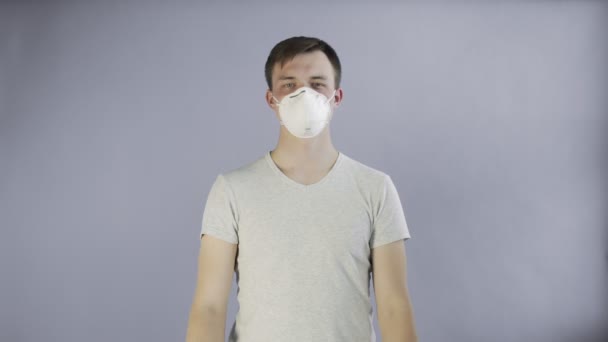 Молодой человек-активист с маской на лице и плакатом ПОМОЩИ на сером фоне — стоковое видео