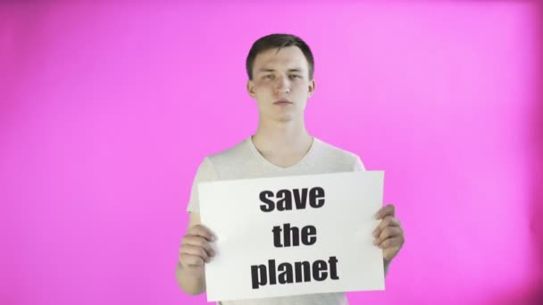 Joven activista con afiche Save The Planet sobre fondo rosa — Vídeos de Stock