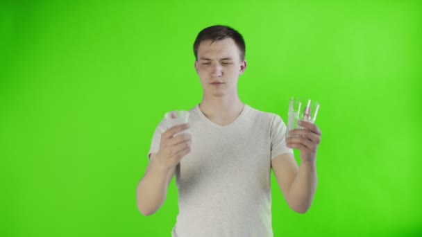 若い男の活動家とともにプラスチックとガラスカップ上クロマキー背景 — ストック動画