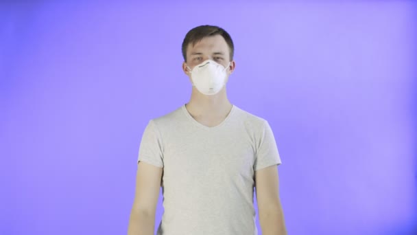 Mladý muž aktivista s maskou na obličeji a s plakátem HELP na fialovém pozadí — Stock video
