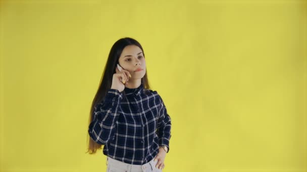 Joven hermosa chica hablando por teléfono en amarillo Fondo en Studio — Vídeos de Stock