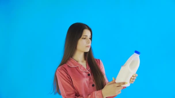 Νεαρή κοπέλα με πιτζάμες πίνει γάλα — Αρχείο Βίντεο