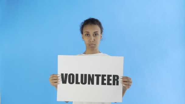 Αφρο-Αμερικανίδα ακτιβίστρια με αφίσα εθελοντών σε μπλε φόντο — Αρχείο Βίντεο