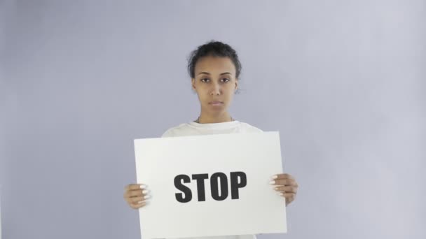 Activista afroamericana con afiche Stop sobre fondo gris — Vídeo de stock