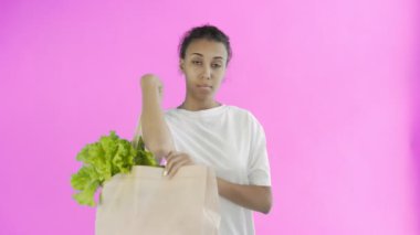 Pembe arka planda plastik ve cam bardakları olan Afro-Amerikalı Kız Eylemci