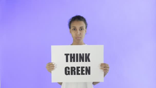 Activista afroamericana con cartel de Think Green sobre fondo violeta — Vídeos de Stock