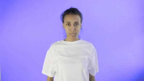 Schöne junge Frau mit schrecklichen Kopfschmerzen auf violettem Hintergrund — Stockvideo