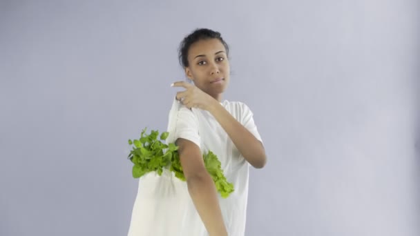 灰色の背景に野菜の入った袋を持つ女性 — ストック動画