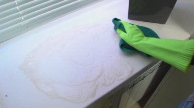 Mavi nemli bez ile yeşil koruyucu eldiven bir el yıkıyor ve toz ve kir gelen pencere pervazı temizler.