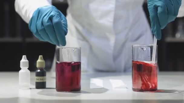 Bilim adamı test tüplerinde kırmızı kimyasal madde karıştırma, reaksiyon gözlemleme — Stok video