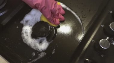 Mutfakta kadın el gaz soba, köpük deterjan yakın çekim ile sünger yıkayın