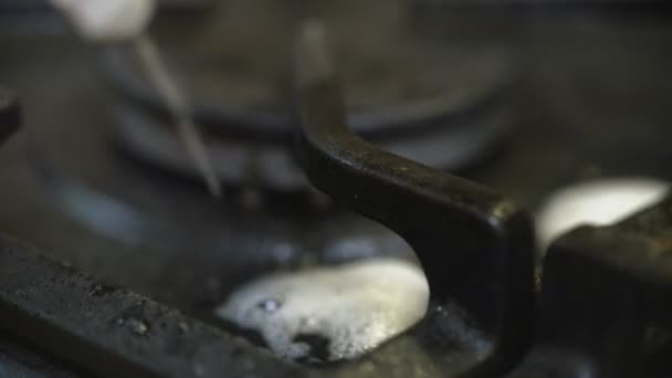 Mano di donna in cucina lavare la stufa a gas, spugna con detergente espanso primo piano — Video Stock