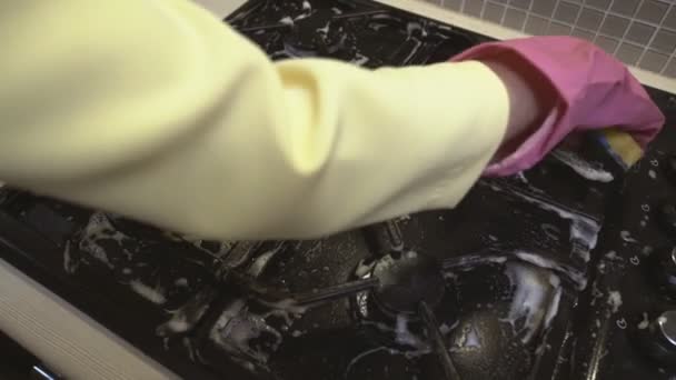 Womans mão na luva de borracha lava fogão a gás sujo com uma esponja . — Vídeo de Stock