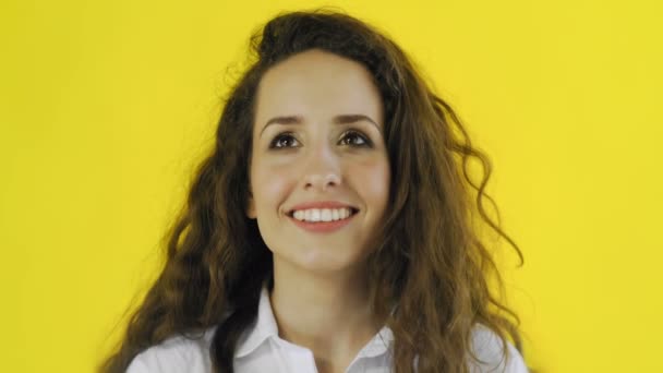 Bardzo szczęśliwa kobieta stojąca na żółtym tle i uśmiechnięta — Wideo stockowe