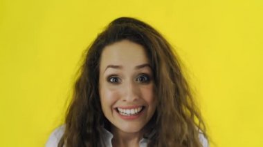 Genç, güzel, beyaz kadın sarı arka planda çok mutlu. Kadın iyi haberi duydu.