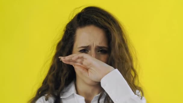 A young beautiful woman cries in yellow screen studio — Stock Video