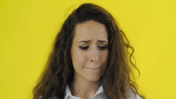Upprörd ung brunett kvinna porträtt på gul bakgrund. Ung flicka besviken — Stockvideo