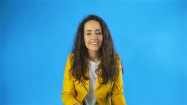 Bir kadın zevk alır. Stüdyoda gözlerini mavi arka planla kapatır..