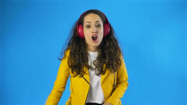 Ung kvinna dansar medan hon lyssnar musik på hörlurar — Stockvideo