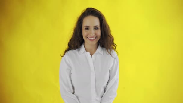 Retrato de menina sorridente no estúdio. Mulher alegre sorridente no fundo amarelo. Beleza feminina natural . — Vídeo de Stock