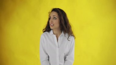 Utangaç kadın, sarı arka planda izole edilmiş kameraya bakmamaya çalış.