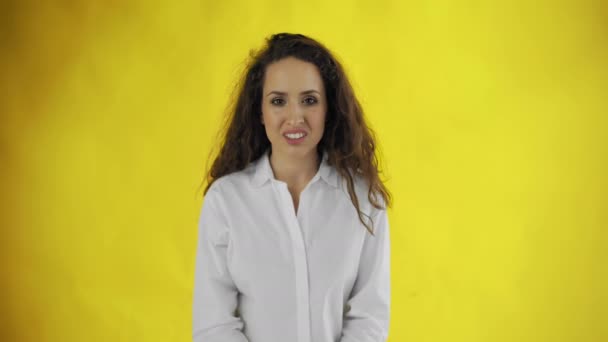 Portrait of a young woman feeling disgust on yellow background — Stock Video