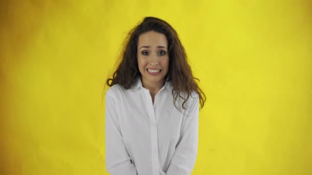 Verlegen jonge vrouw is shrugging bukken schuldig verbreden ogen grijnzen ongemakkelijk verontschuldigen — Stockvideo