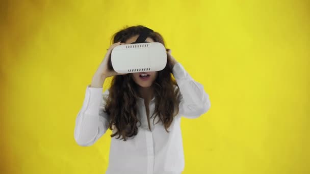 Jovem feliz vestindo fone de ouvido Realidade Virtual em fundo amarelo no estúdio — Vídeo de Stock