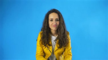 Kafası karışmış bir kadın sarı arka plan için kafa sallamak yok diyor.