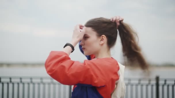 Frau, die Haare im Pferdeschwanz bindet, bereitet sich auf den Lauf vor — Stockvideo