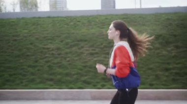 Parkta koşan koşucu kadın spor yapıyor, spor yapıyor, takip edilebilir teknoloji kullanıyor.