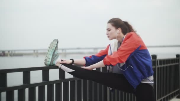Dışarı çıkmadan önce spor yapan kadın bacaklarını esnetiyor. — Stok video