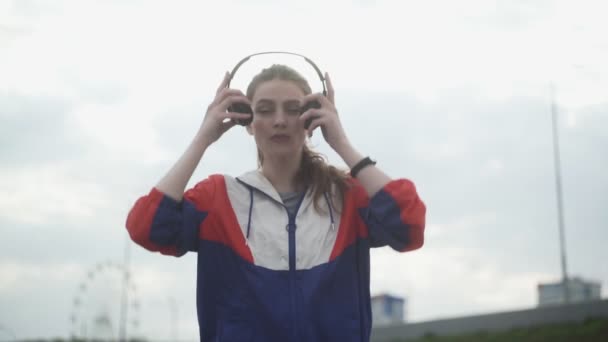 Jovem está usando fone de ouvido para motivação musical e fugindo — Vídeo de Stock