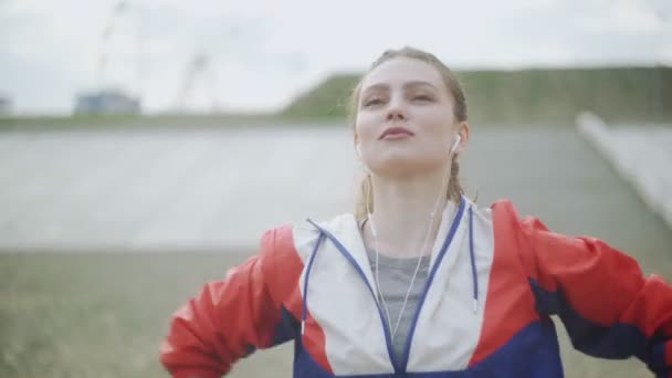 Saludable hermosa joven atleta mujer en ropa deportiva estirando los brazos y el cuerpo para listo para correr en la calle en el parque urbano de la ciudad — Vídeos de Stock